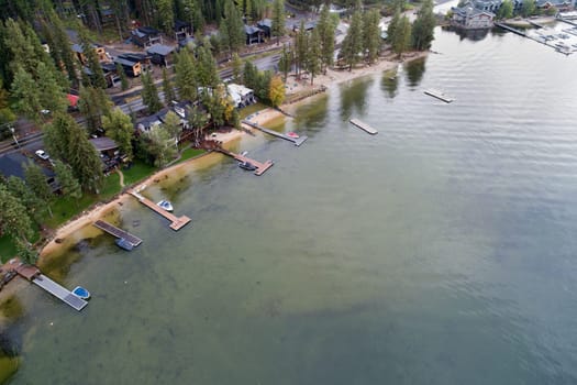 A view of a lake with a few boats docked at the marina. The water is green and the sky is cloudy