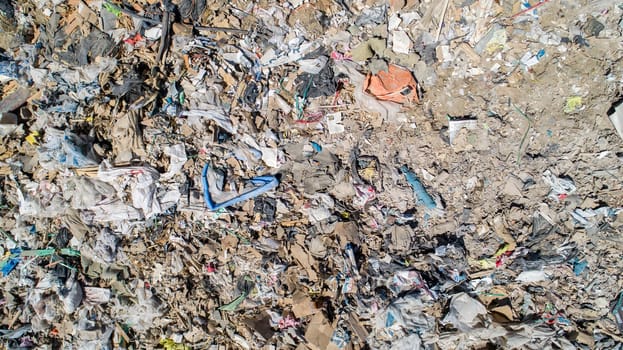 A pile of trash with a blue object in the middle. The trash is scattered all over the ground