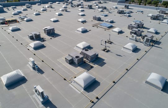 A large building with many vents and a roof. The roof is white and the vents are black