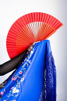 Flamenco dance vibes. Red fan with blue floral shawl in passionate style.