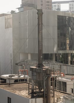 Bangkok, Thailand 23 Dec, 2024 - Boiler soot separator chimney on roof of building with modern buildings in the background. use it as your Wallpaper, Poster and Copy space, Selective focus.