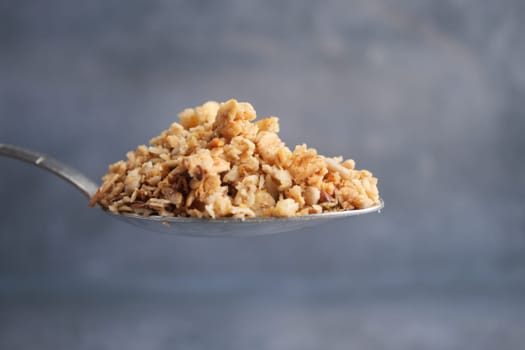 Granola on a silver spoon highlights its crunch and color.