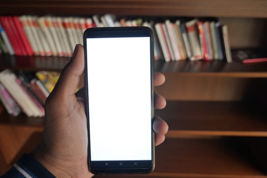 User shows a blank smartphone screen next to nearby books.