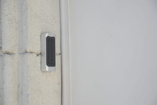 Access control device features a numeric keypad on a concrete wall.