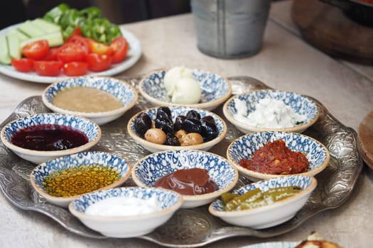 Assorted sauces and dips displayed on a tray with fresh vegetables.