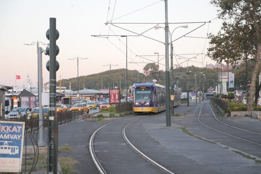 Tram moves along the tracks as day transitions to night in the city.
