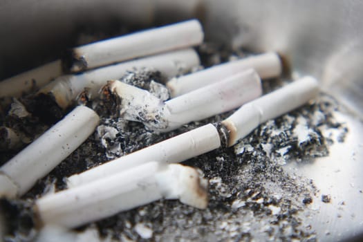 Butts remain in an ashtray, indicating a recent social event or gathering.