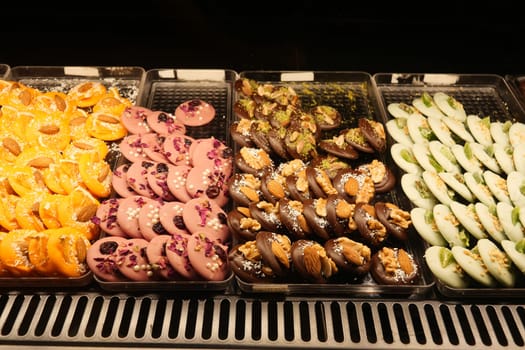 Various traditional sweets arranged in neat sections at a market stall.