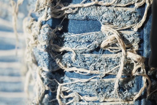 Frayed denim with intricate textures reflects sunlight beautifully.
