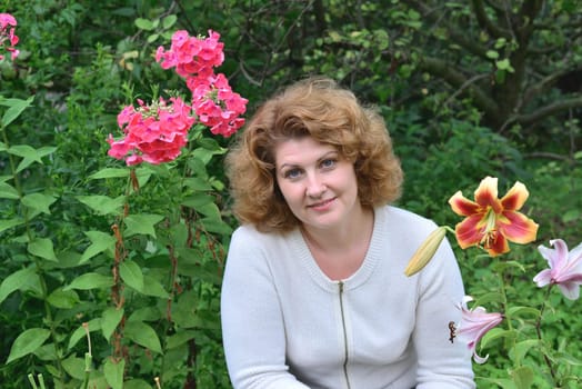 Woman in garden surrounded by a flowers