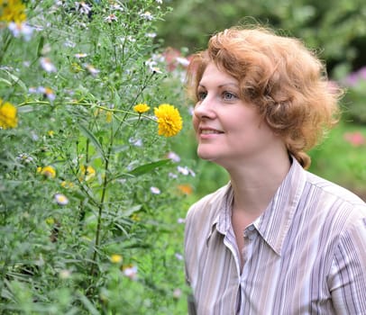 Woman in garden surrounded by a flowers