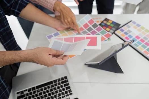 Team members engage in a creative review session, analyzing color swatches and design options to inspire new projects and campaigns.