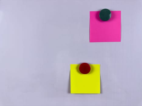 Pink and yellow sticky notes with magnets on whiteboard perfect for reminders and scheduling in various settings providing a colorful solution for organization and communication