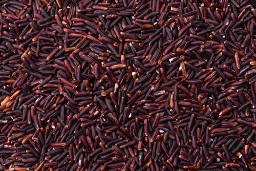 Red or brown raw rice in a ceramic bowl. Rice as an ingredient in Asian organic food
