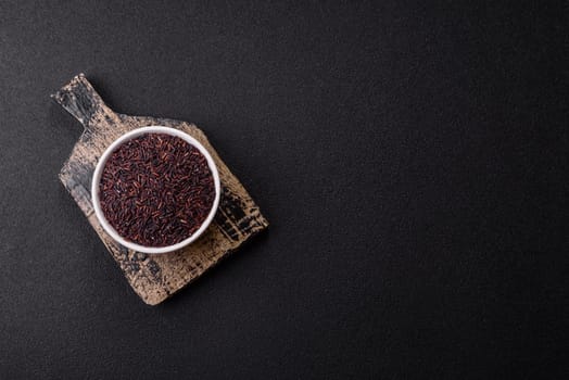 Red or brown raw rice in a ceramic bowl. Rice as an ingredient in Asian organic food