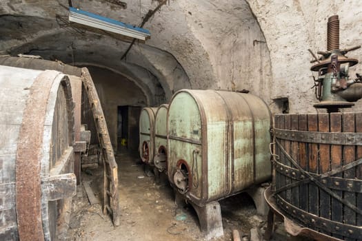 Vintage cellar winery with dusty bottles and wine barrels