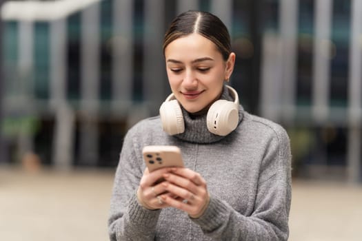 Work from anywhere, thrive everywhere. A remote freelancer in casual wear uses headphones and a phone to manage projects on the go, embracing the freedom of digital nomadism.