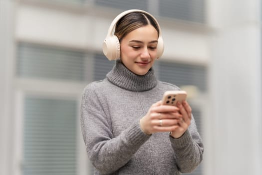 Tune in, zone out, recharge. A relaxed woman enjoys music or a podcast on her phone with headphones, finding a peaceful escape into sound while blending technology with well-being.