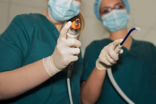Hands of dentists surgeons with forceps and instruments for dental treatment