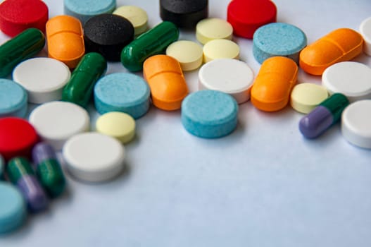 Colorful pills and capsules scattered on white cover background with customizable space for text