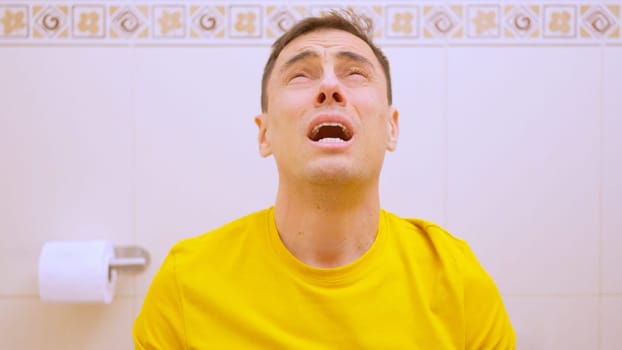 Man experiencing severe stomach pain while using the toilet, highlighting digestive problems and discomfort