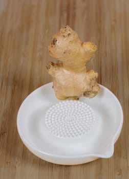 Closeup of a ceramic ginger grater an a ginger root