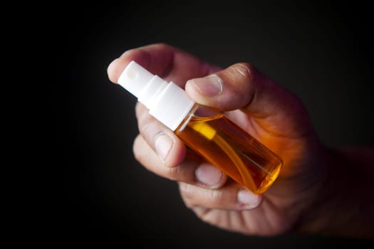 Hand holding a mouth spray bottle .