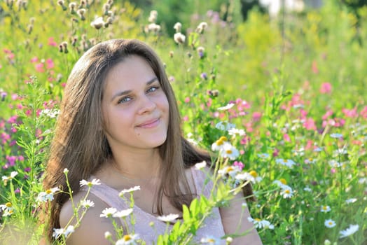 Happy 16 year old girl surrounded by a blooming field