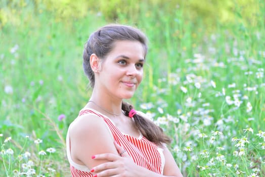 Happy 16 year old girl surrounded by a blooming field