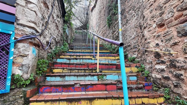 Brightly painted steps ascend through a charming, narrow alleyway.
