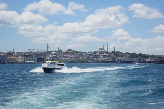 A ferry navigates the Bosphorus while showcasing the Istanbul skyline.