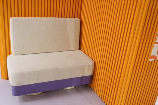 Cozy couch placed in brightly colored room with wooden accents.