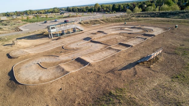 A dirt track with a white line down the middle. The track is surrounded by a dirt field