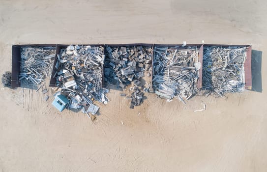 A pile of trash is stacked in a row. The trash is mostly made up of metal and wood. Concept of waste and neglect