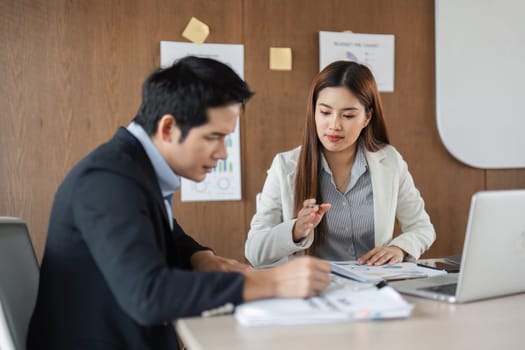 A female colleague explains her findings to a male team member, emphasizing the significance of detailed planning and data management in achieving business objectives.