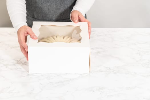 The Carrot Bundt Cake is carefully packaged into a white paper bundt cake box, ready for gifting or sharing.