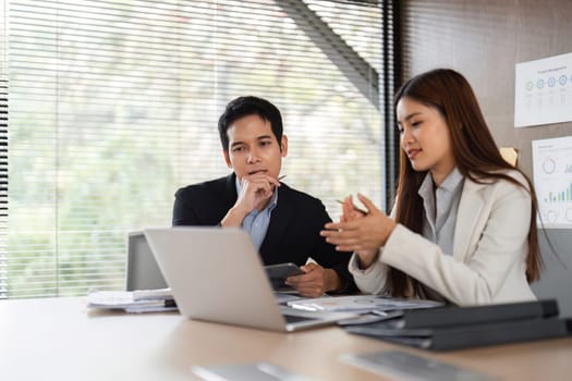 A woman explains a point while a man listens intently, promoting effective communication and collaboration within their business strategies.