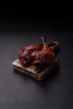 Duck, chicken leg or thigh grilled on a dark concrete background. Duck confit, Asian food with salt and spices