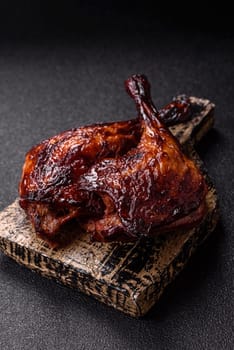 Duck, chicken leg or thigh grilled on a dark concrete background. Duck confit, Asian food with salt and spices