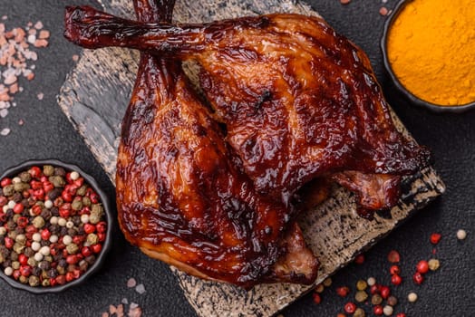 Duck, chicken leg or thigh grilled on a dark concrete background. Duck confit, Asian food with salt and spices