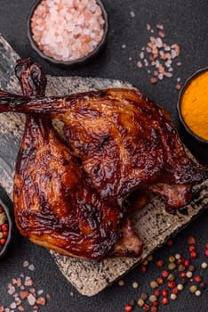 Duck, chicken leg or thigh grilled on a dark concrete background. Duck confit, Asian food with salt and spices
