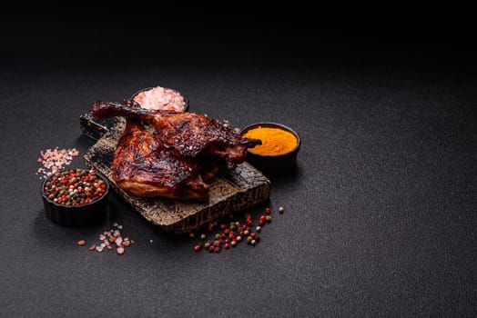 Duck, chicken leg or thigh grilled on a dark concrete background. Duck confit, Asian food with salt and spices
