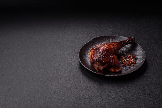Duck, chicken leg or thigh grilled on a dark concrete background. Duck confit, Asian food with salt and spices