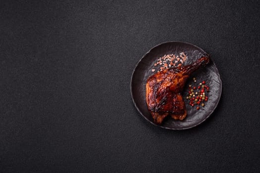 Duck, chicken leg or thigh grilled on a dark concrete background. Duck confit, Asian food with salt and spices
