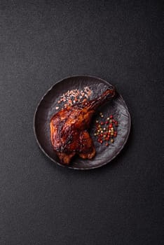 Duck, chicken leg or thigh grilled on a dark concrete background. Duck confit, Asian food with salt and spices