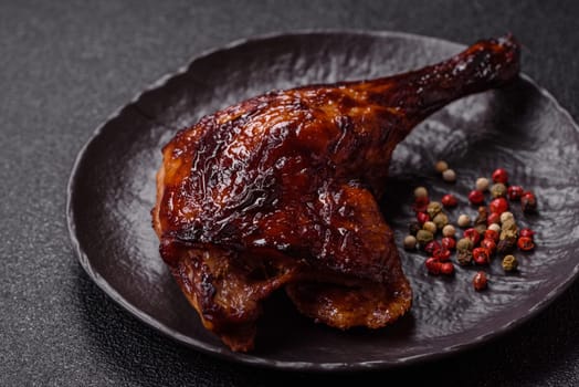 Duck, chicken leg or thigh grilled on a dark concrete background. Duck confit, Asian food with salt and spices