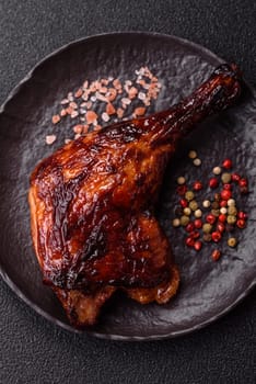 Duck, chicken leg or thigh grilled on a dark concrete background. Duck confit, Asian food with salt and spices