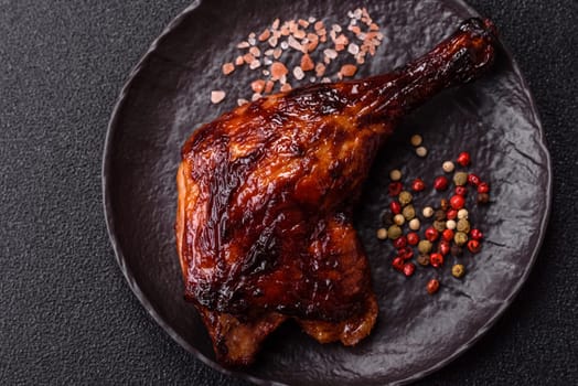 Duck, chicken leg or thigh grilled on a dark concrete background. Duck confit, Asian food with salt and spices