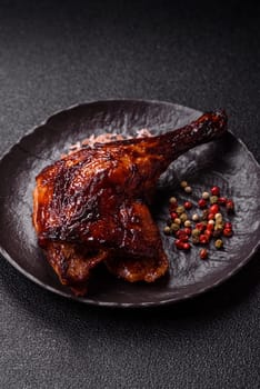 Duck, chicken leg or thigh grilled on a dark concrete background. Duck confit, Asian food with salt and spices