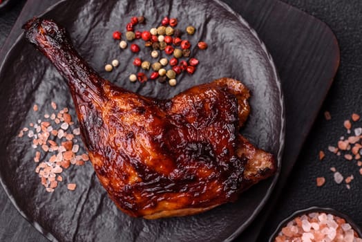 Duck, chicken leg or thigh grilled on a dark concrete background. Duck confit, Asian food with salt and spices